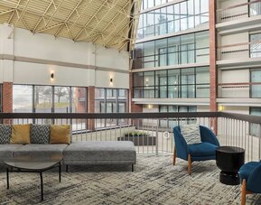 Bright open-air atrium lounge with comfortable seating and natural light at Holiday Inn Oakville Centre.