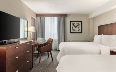 Comfortable guest room with two beds, dedicated workspace, and modern amenities at Holiday Inn Oakville Centre.