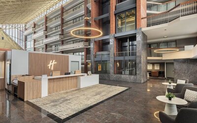 Modern reception area with welcoming front desk and spacious atrium lobby at Holiday Inn Oakville Centre.