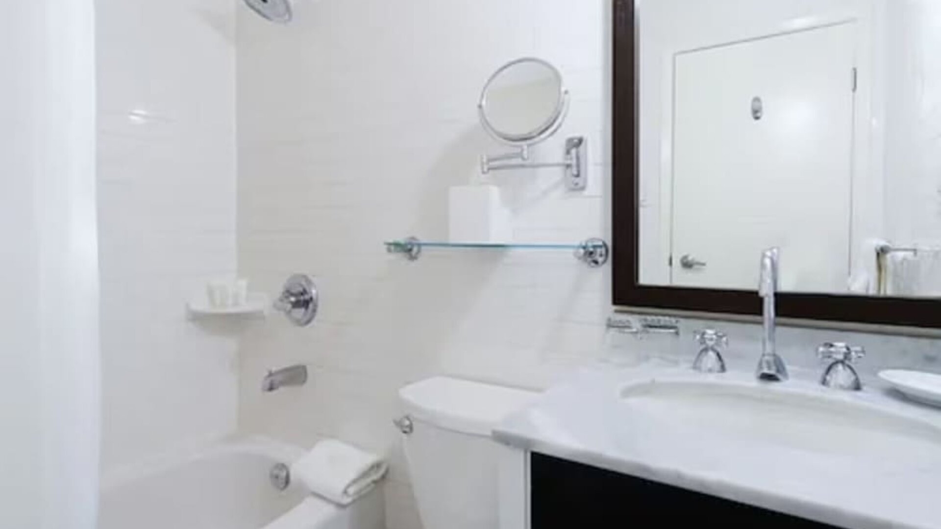 Modern guest bathroom featuring a shower and bathtub combination, spacious vanity, and complimentary bath amenities at ARC The Hotel Ottawa.
