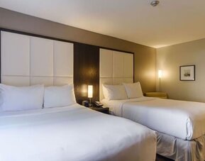 Comfortable guest room with two beds, premium bedding, and modern amenities for families or groups at ARC The Hotel Ottawa.