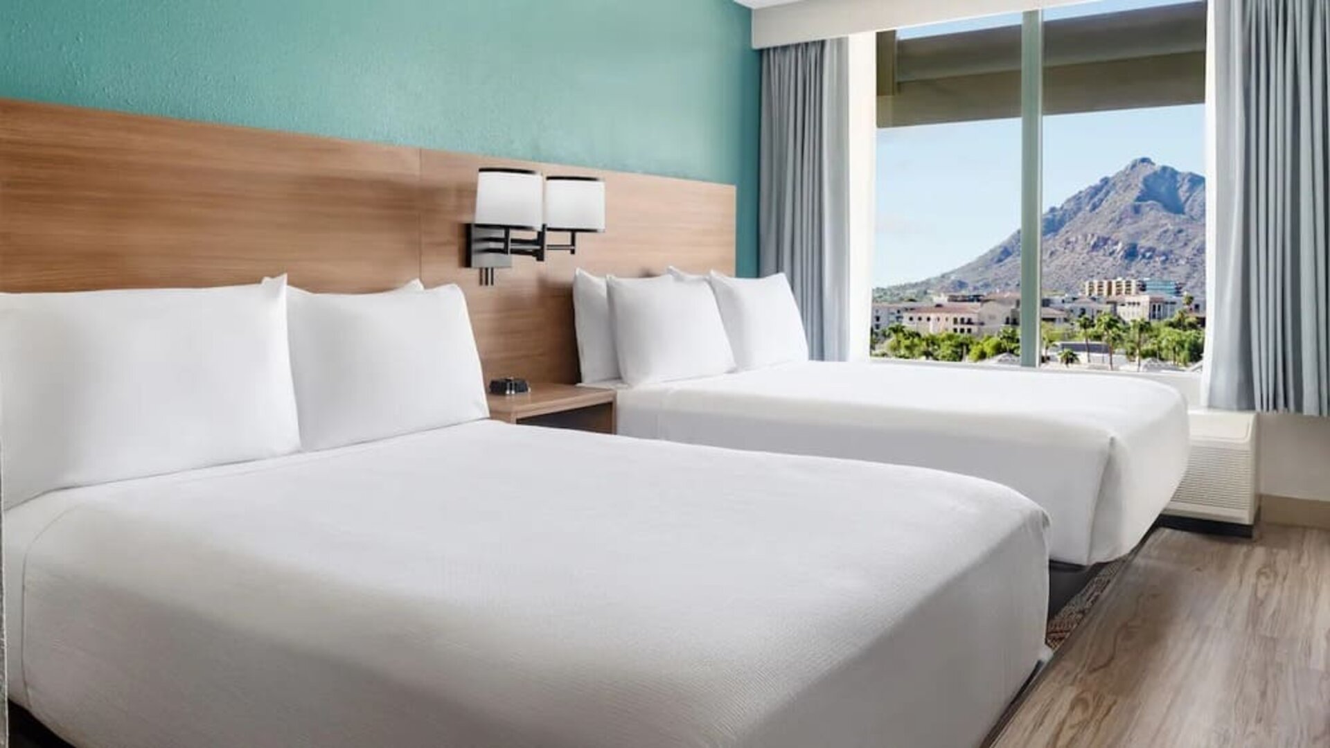 Double queen guest room featuring two plush beds, modern furnishings, and stunning mountain views at Hyatt Place Scottsdale/Old Town.
