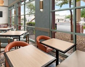 Bright dining area with comfortable seating and floor-to-ceiling windows, perfect for breakfast, coffee, or casual meals at Hyatt Place Scottsdale/Old Town.
