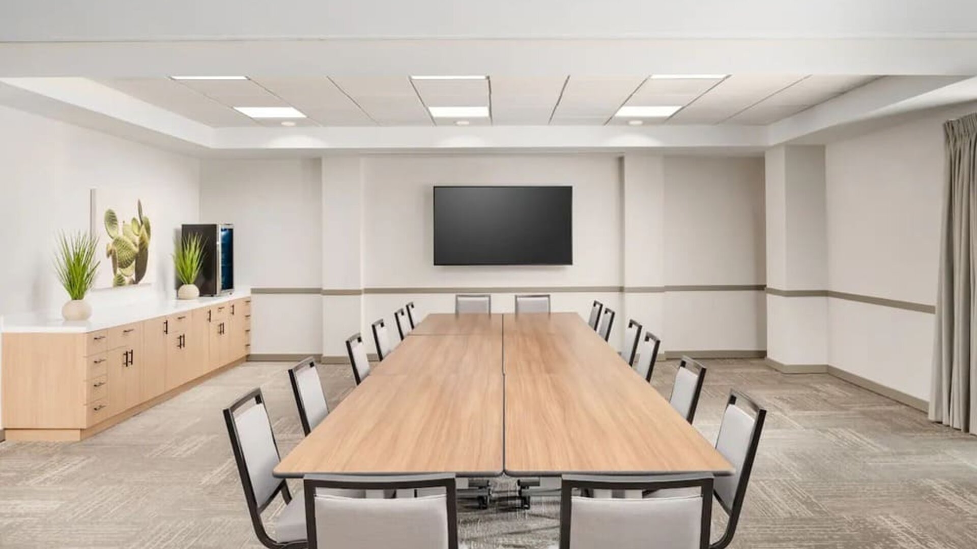 Flexible meeting room with modern furnishings, presentation screen, and space for business meetings or private events at Hyatt Place Scottsdale/Old Town.