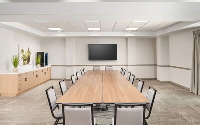 Flexible meeting room with modern furnishings, presentation screen, and space for business meetings or private events at Hyatt Place Scottsdale/Old Town.