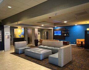 Contemporary hotel lobby with comfortable lounge seating, modern décor, and welcoming social spaces at Courtyard Riverside UCR/Moreno Valley Area.