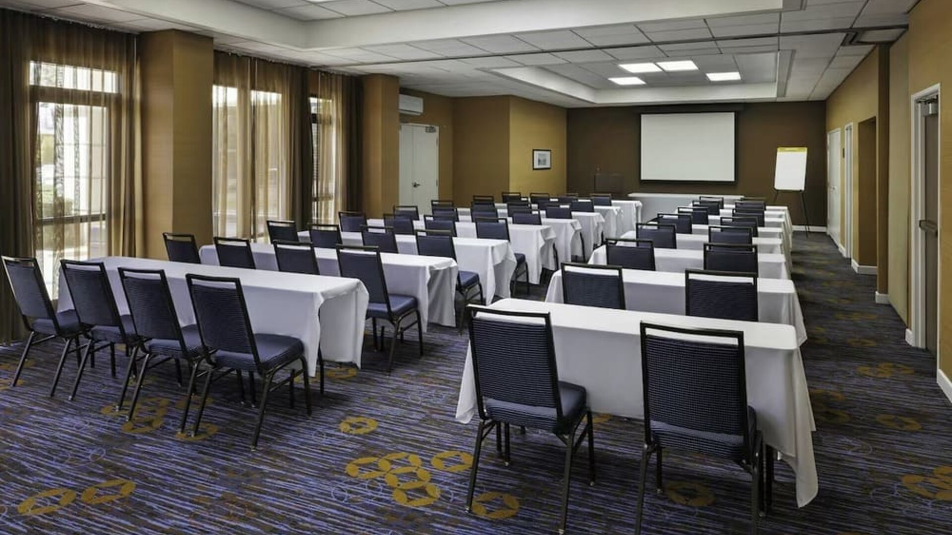 Flexible meeting room with classroom-style seating, audiovisual capabilities, and natural light for conferences and events at Courtyard Riverside UCR/Moreno Valley Area.