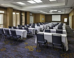 Flexible meeting room with classroom-style seating, audiovisual capabilities, and natural light for conferences and events at Courtyard Riverside UCR/Moreno Valley Area.