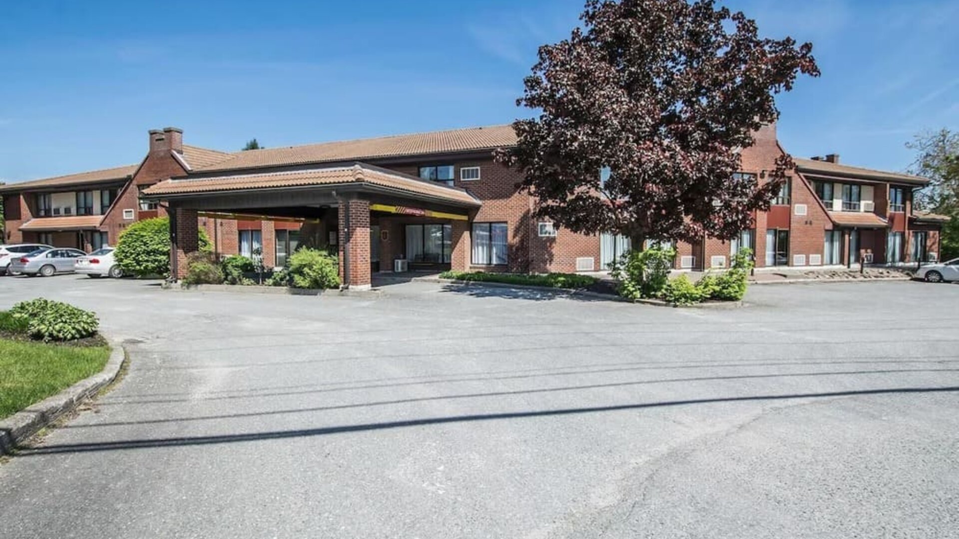 Exterior view of Comfort Inn Sherbrooke with convenient guest parking and a covered hotel entrance.