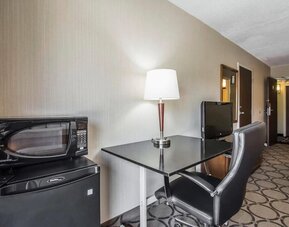 In-room workspace featuring a desk, ergonomic chair, microwave, mini refrigerator, and coffee service at Comfort Inn Sherbrooke.