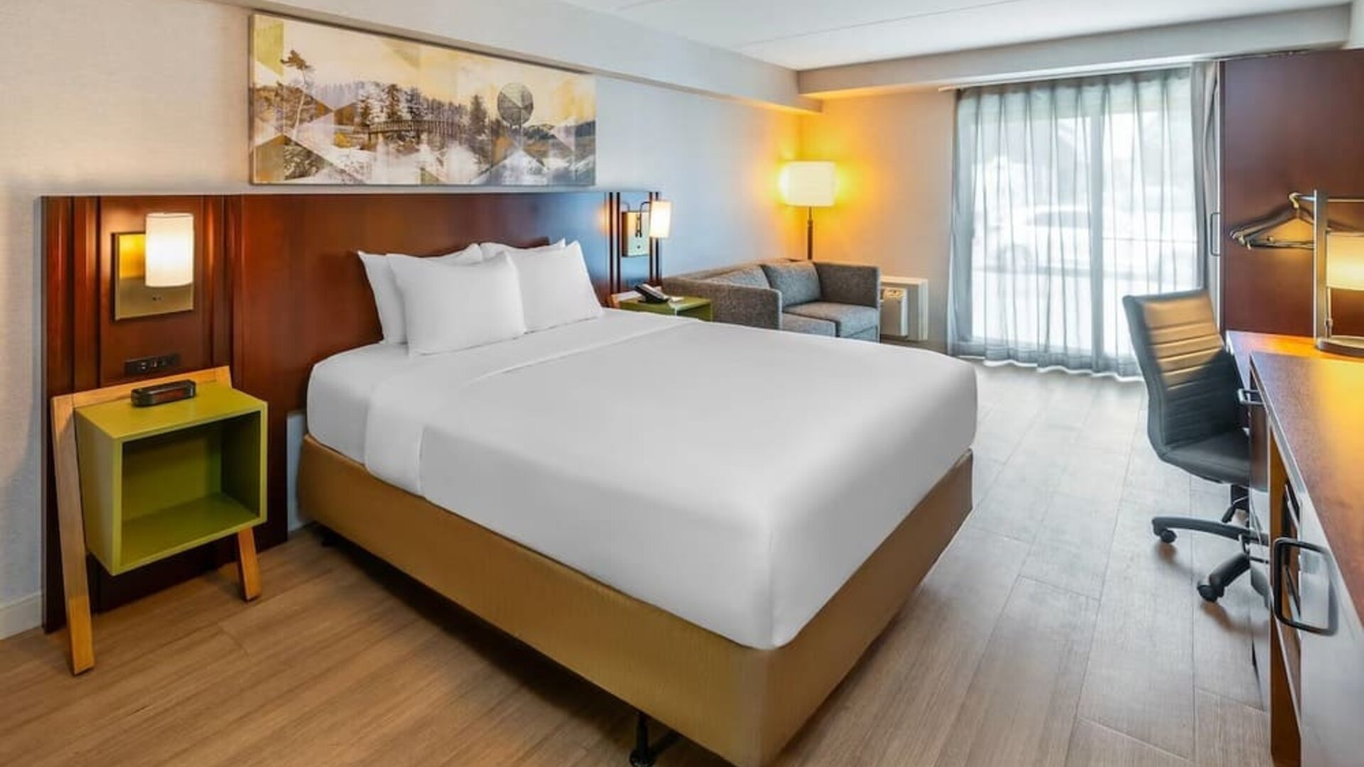 King guest room featuring a comfortable king bed, seating area, work desk, and natural light at Comfort Inn Sudbury Regent Street.