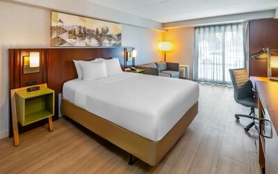 King guest room featuring a comfortable king bed, seating area, work desk, and natural light at Comfort Inn Sudbury Regent Street.