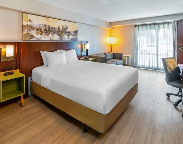 King guest room featuring a comfortable king bed, seating area, work desk, and natural light at Comfort Inn Sudbury Regent Street.
