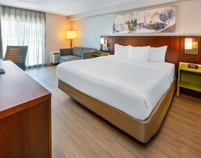 King guest room featuring a comfortable king bed, seating area, work desk, and modern amenities at Comfort Inn Sudbury Regent Street.