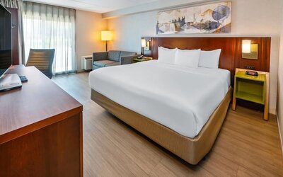 King guest room featuring a comfortable king bed, seating area, work desk, and modern amenities at Comfort Inn Sudbury Regent Street.