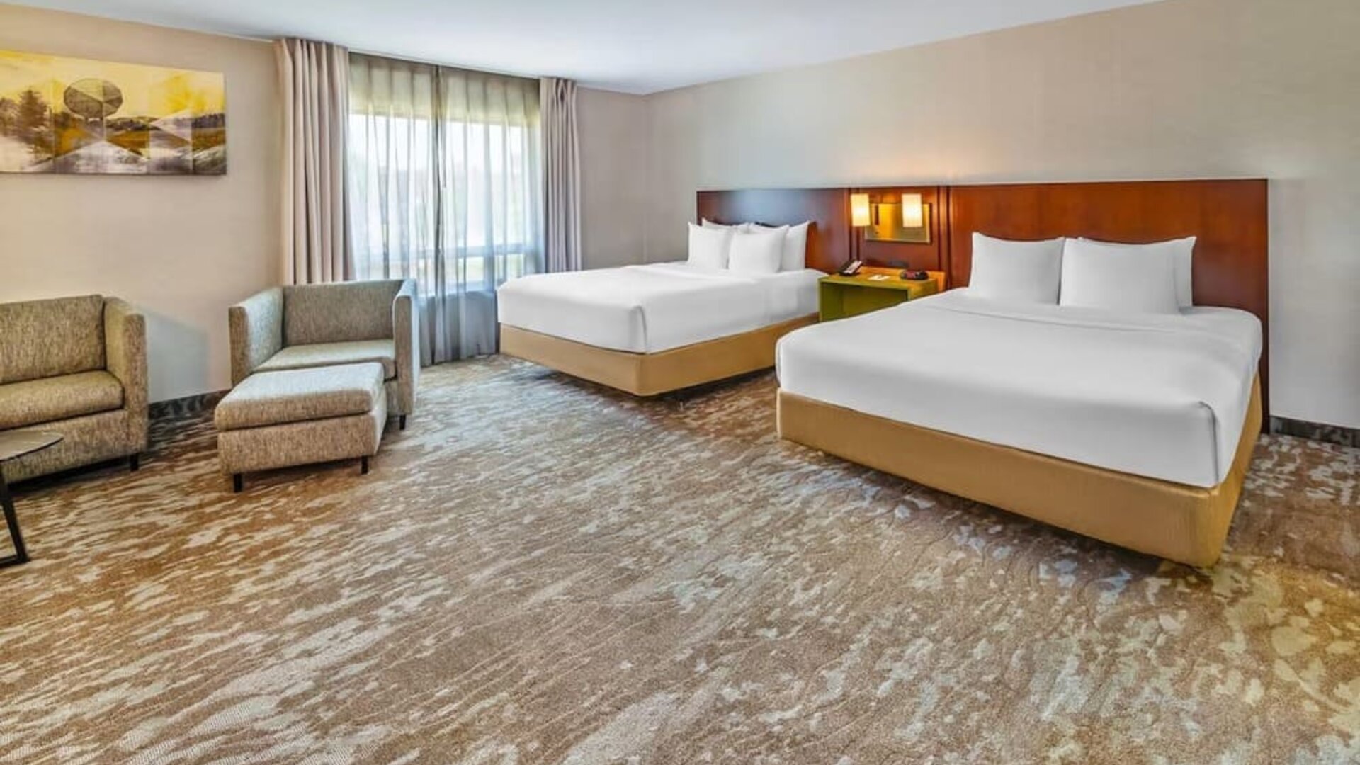 Spacious guest room featuring two queen beds, comfortable seating, and modern accommodations at Comfort Inn Sudbury Regent Street.