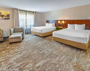 Spacious guest room featuring two queen beds, comfortable seating, and modern accommodations at Comfort Inn Sudbury Regent Street.