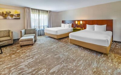 Spacious guest room featuring two queen beds, comfortable seating, and modern accommodations at Comfort Inn Sudbury Regent Street.