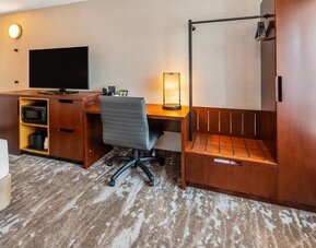 In-room workspace with a desk, ergonomic chair, HDTV, microwave, coffee maker, and luggage rack at Comfort Inn Sudbury Regent Street.