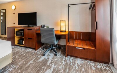 In-room workspace with a desk, ergonomic chair, HDTV, microwave, coffee maker, and luggage rack at Comfort Inn Sudbury Regent Street.