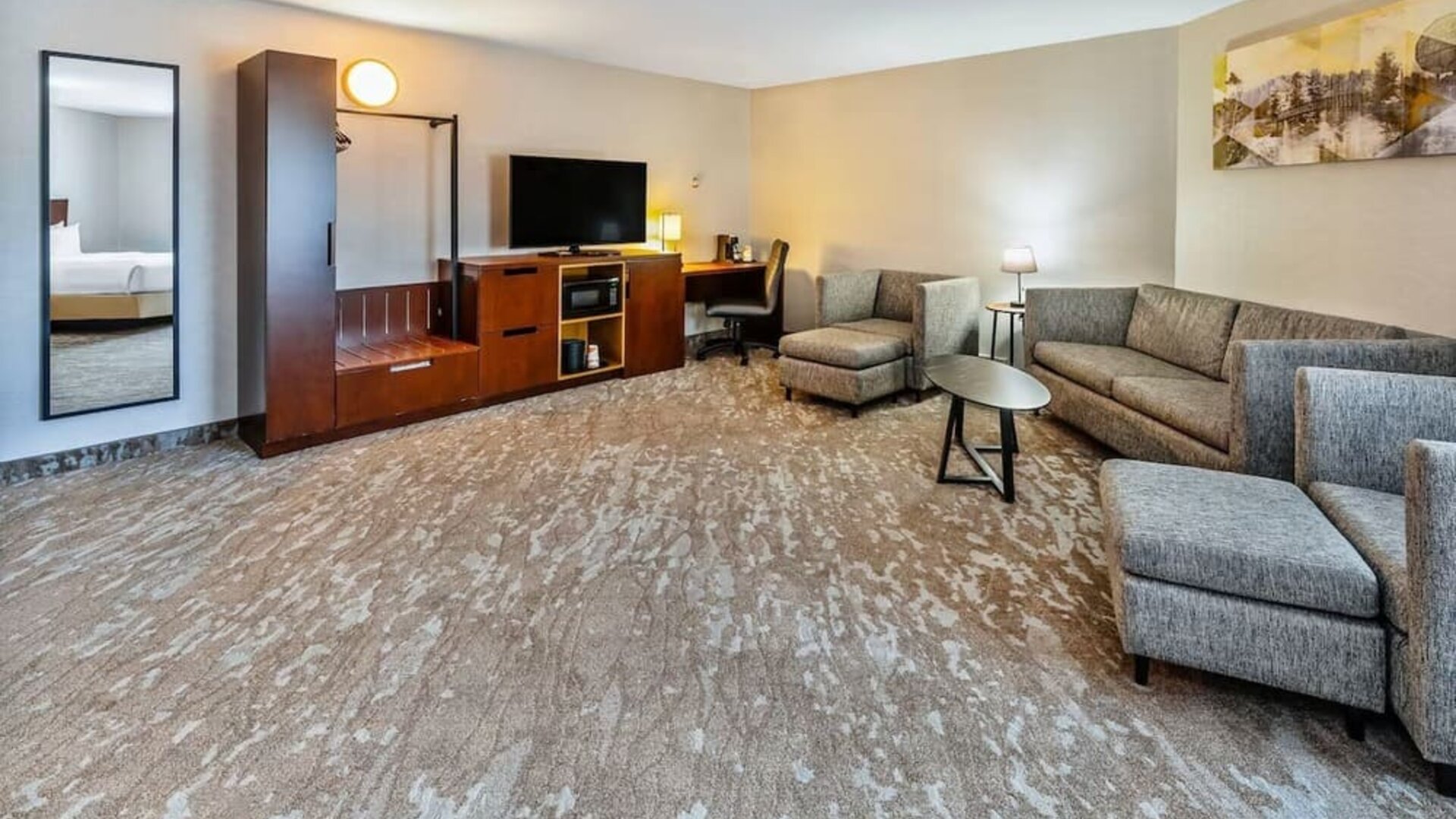 Spacious suite featuring a comfortable seating area, work desk, HDTV, and modern furnishings at Comfort Inn Sudbury Regent Street.