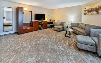 Spacious suite featuring a comfortable seating area, work desk, HDTV, and modern furnishings at Comfort Inn Sudbury Regent Street.