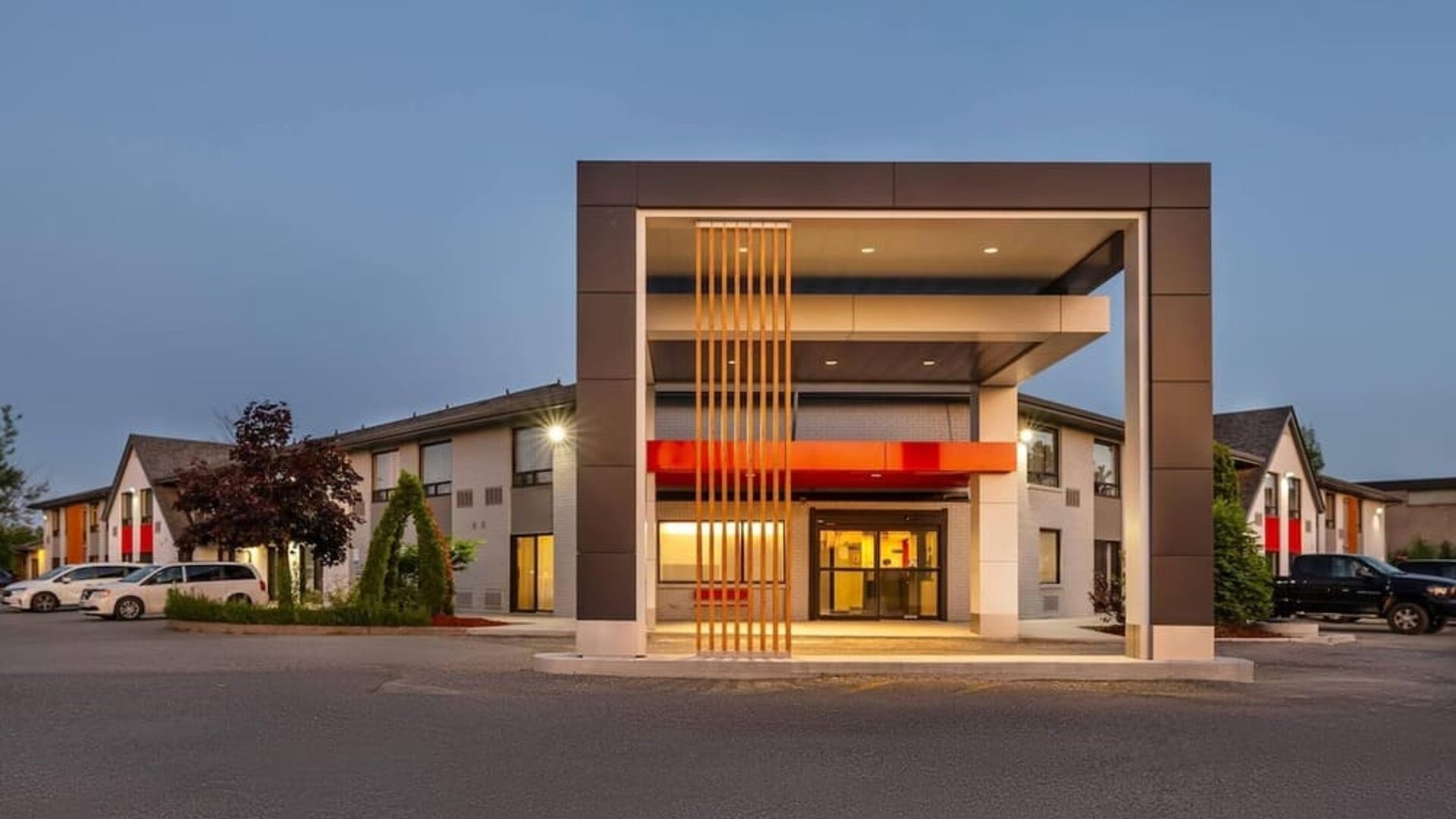 Exterior view of Comfort Inn Sudbury Regent Street featuring ample guest parking and a covered hotel entrance.