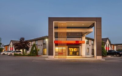 Exterior view of Comfort Inn Sudbury Regent Street featuring ample guest parking and a covered hotel entrance.