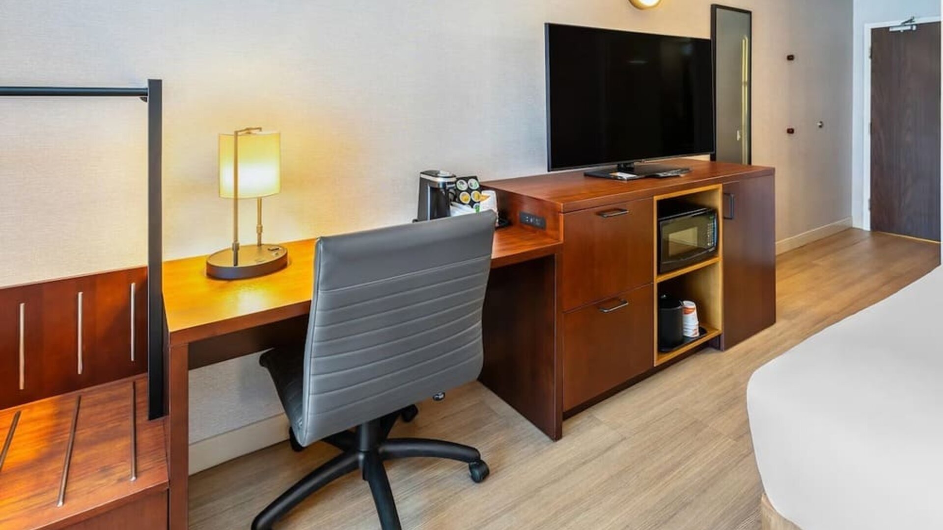 In-room workspace with a desk, ergonomic chair, HDTV, microwave, coffee maker, and luggage storage at Comfort Inn Sudbury Regent Street.