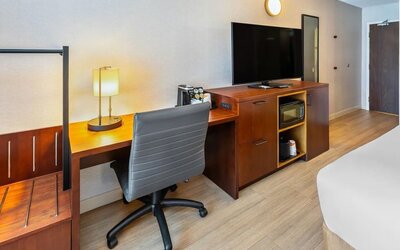 In-room workspace with a desk, ergonomic chair, HDTV, microwave, coffee maker, and luggage storage at Comfort Inn Sudbury Regent Street.