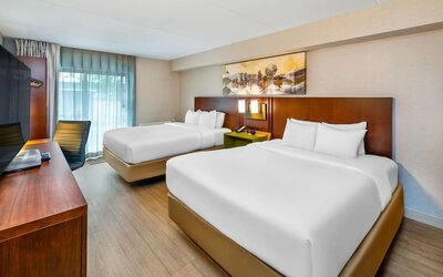 Guest room with two queen beds, hardwood flooring, workspace, and modern décor at Comfort Inn Sudbury East.