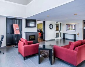 Lobby lounge featuring comfortable seating, fireplace, and access to the breakfast area at Comfort Inn Sudbury East.