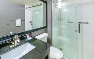 Modern guest bathroom with a walk-in shower, granite vanity, and fresh towels at Comfort Inn Sudbury East.