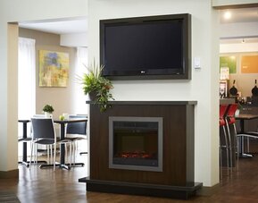 Inviting lobby featuring a fireplace, seating area, and breakfast space at Comfort Inn Sudbury East.