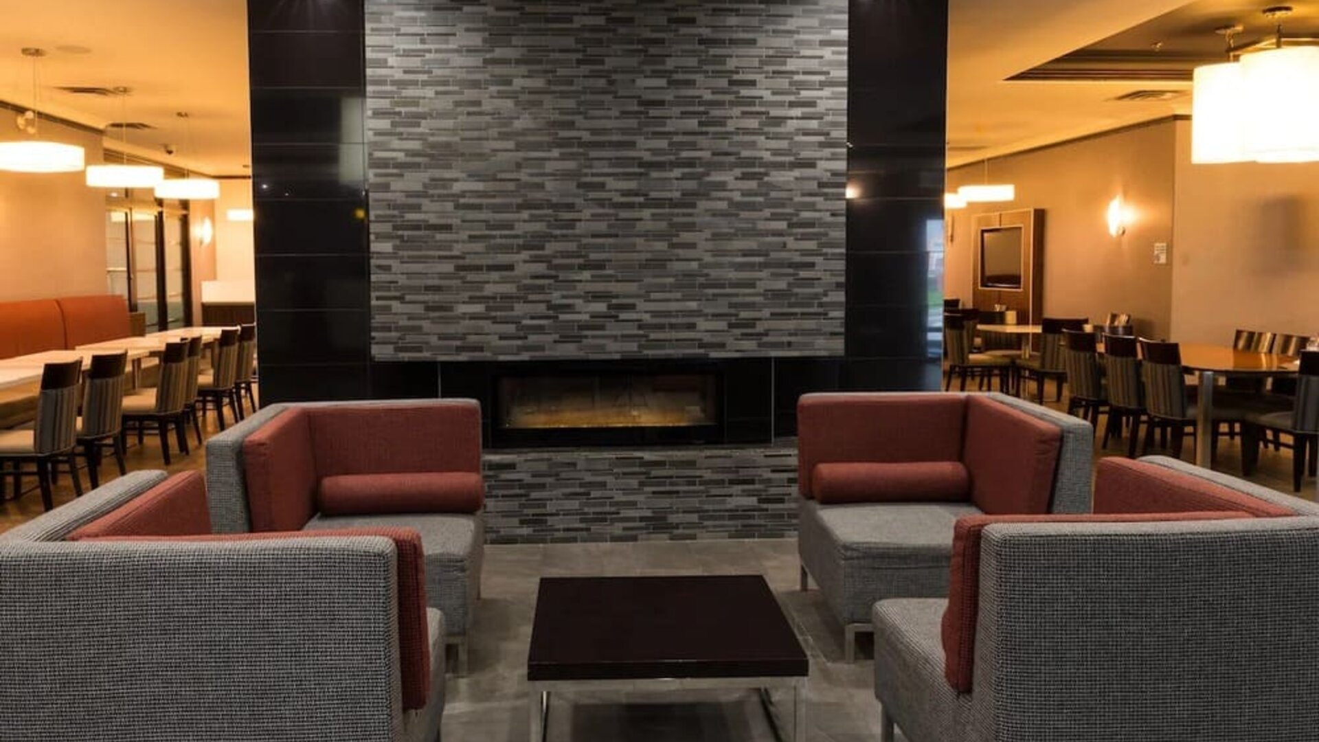 Lobby seating area with a fireplace and contemporary furnishings at Holiday Inn Express Edmonton Downtown, an IHG Hotel.