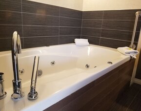 Guest bathroom with a jetted soaking tub at Holiday Inn Express Edmonton Downtown, an IHG Hotel.