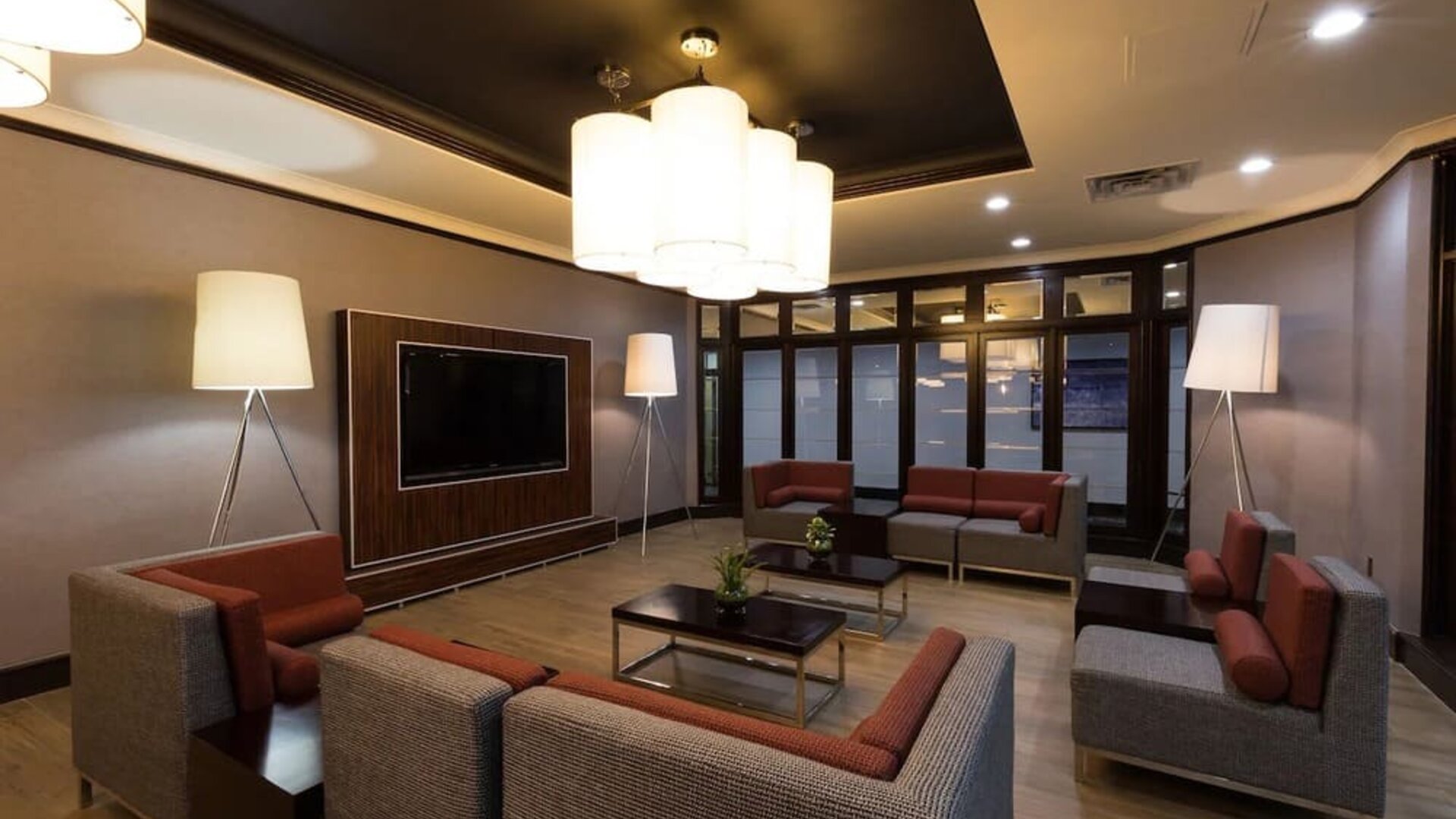 Modern hotel lobby with comfortable seating, large TV, and stylish lighting at Holiday Inn Express Edmonton Downtown, an IHG Hotel.