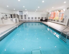 Indoor swimming pool with lounge seating at Holiday Inn Express Edmonton Downtown, an IHG Hotel.