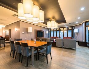 Restaurant and lounge seating area with modern décor at Holiday Inn Express Edmonton Downtown, an IHG Hotel.