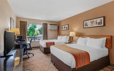 Guest room with two queen beds and a work desk at Comfort Inn Brantford.
