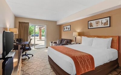 Spacious guest room with a king bed, sofa, and work desk at Comfort Inn Brantford.
