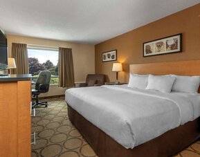 King guest room with natural light and seating area at Comfort Inn Sept-Iles.