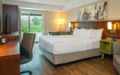Spacious king guest room with a sofa and work desk at Comfort Inn Sault Ste. Marie.
