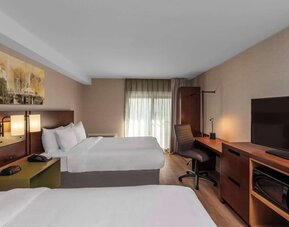 Guest room with two queen beds and a work desk at Comfort Inn Sault Ste. Marie.