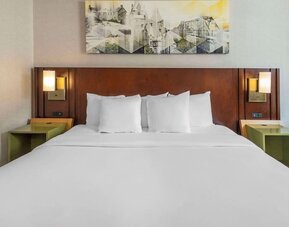 King bed with bedside tables and wall art at Comfort Inn Sault Ste. Marie.