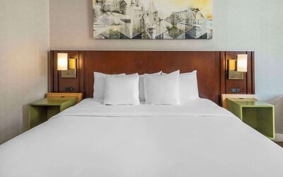 King bed with bedside tables and wall art at Comfort Inn Sault Ste. Marie.