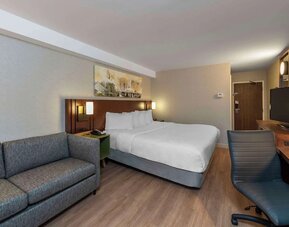 Spacious king guest room with a sofa and work desk at Comfort Inn Sault Ste. Marie.