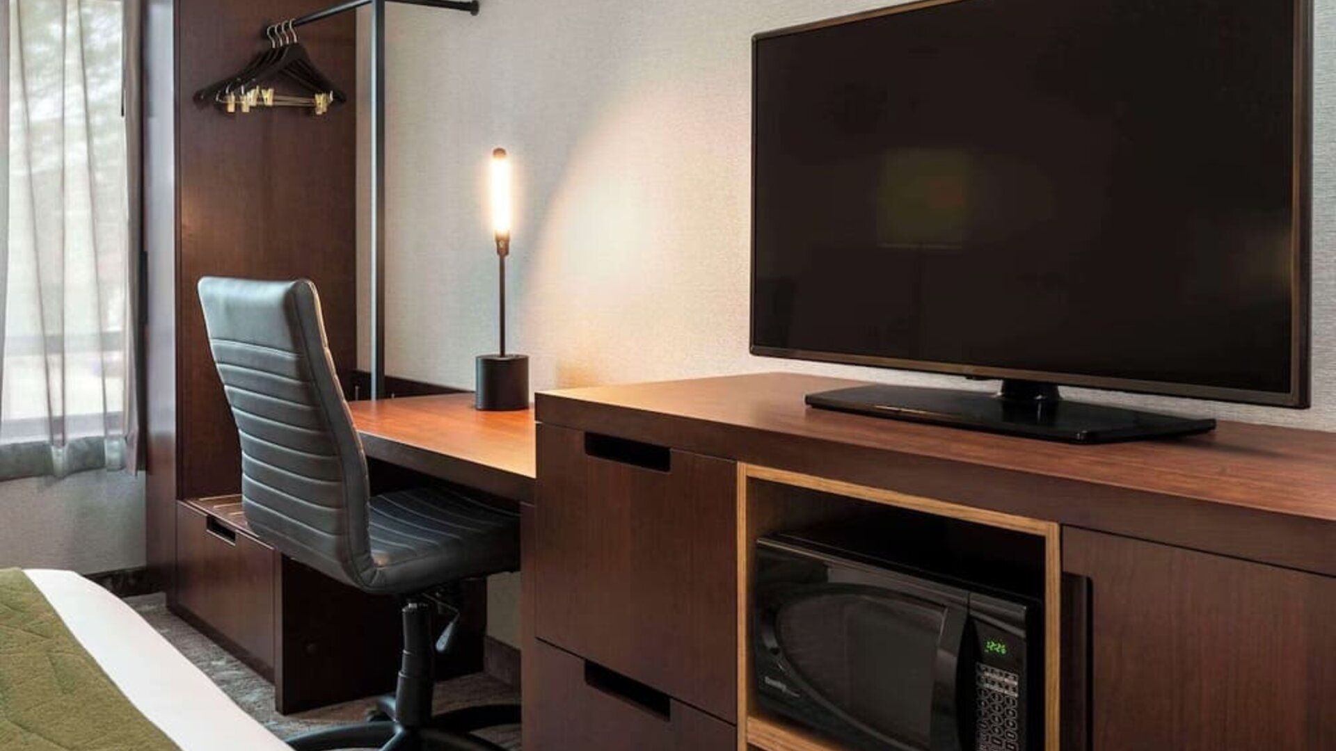 Guest room workspace with a desk, TV, and microwave at Comfort Inn Sault Ste. Marie.