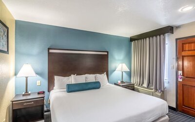 Guest room with a king bed and bedside tables at Glenridge Inn Glendale Pasadena.
