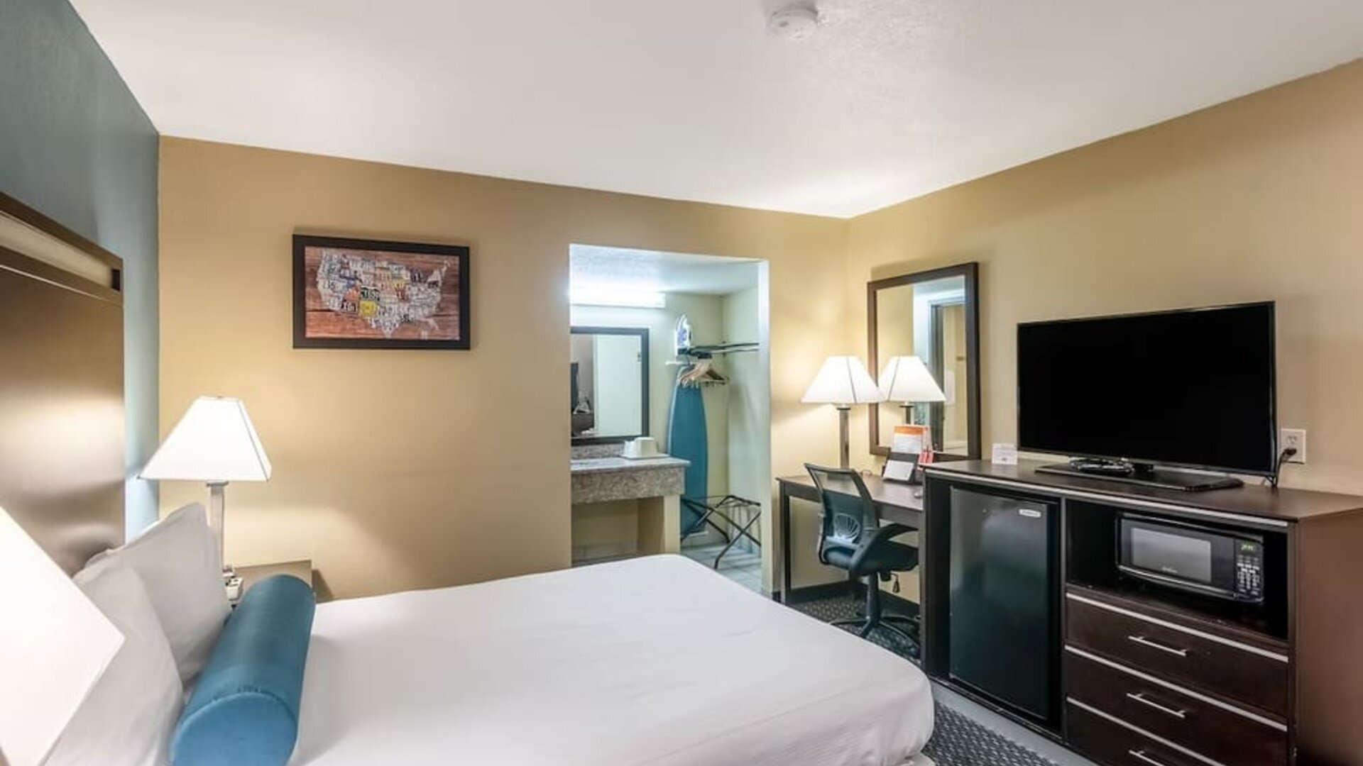 Guest room with a king bed, work desk, TV, microwave, and mini fridge at Glenridge Inn Glendale Pasadena.